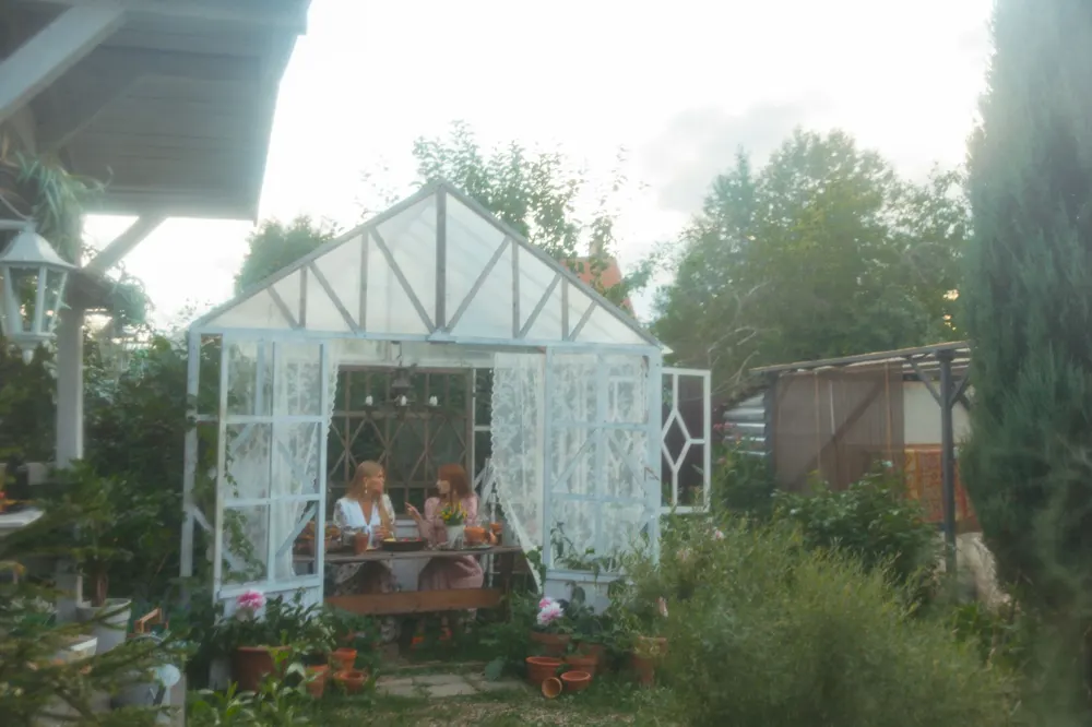 A small white garden pavilion with people seated at a table